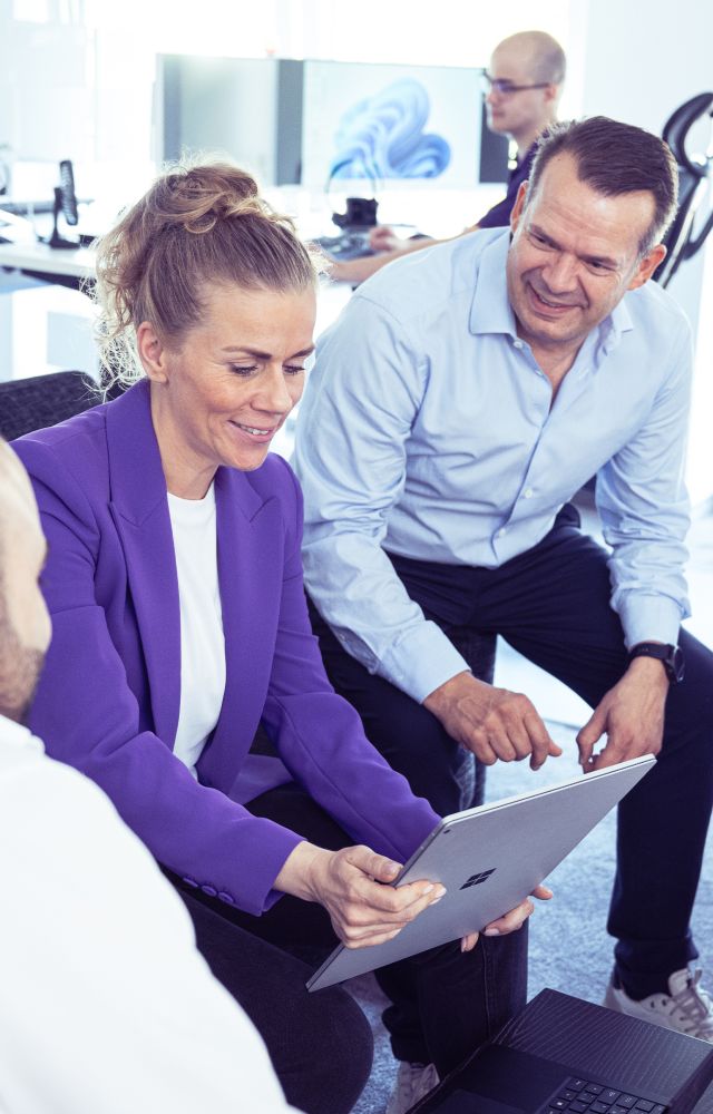 Drei Menschen besprechen etwas am Tablet